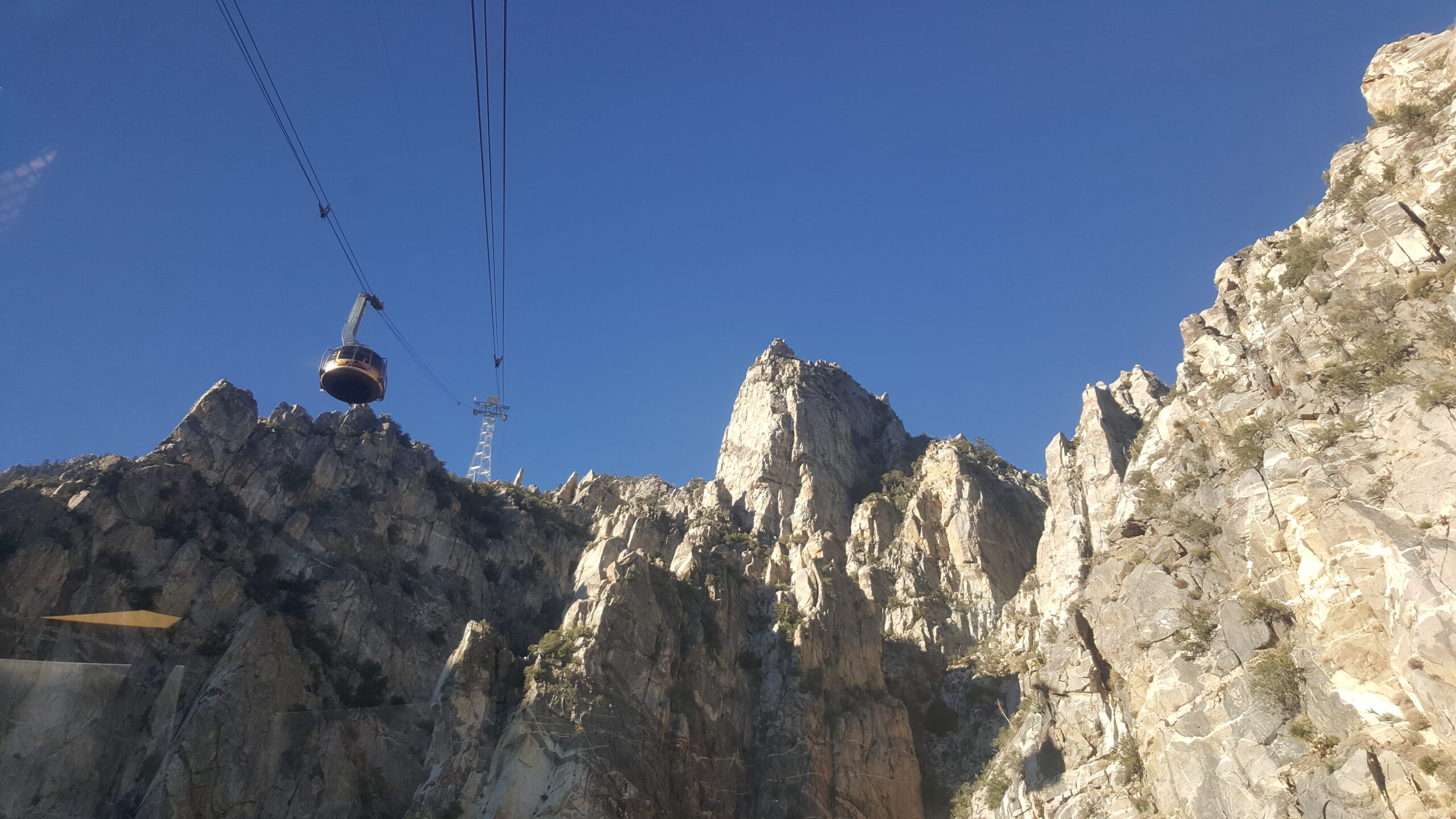 As the tram approaches the station, another tram descends the cable above.