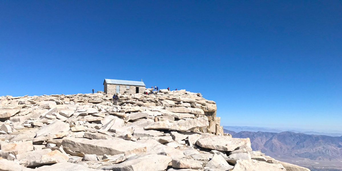 The summit hut rests on many slabs of sun-bleached stone