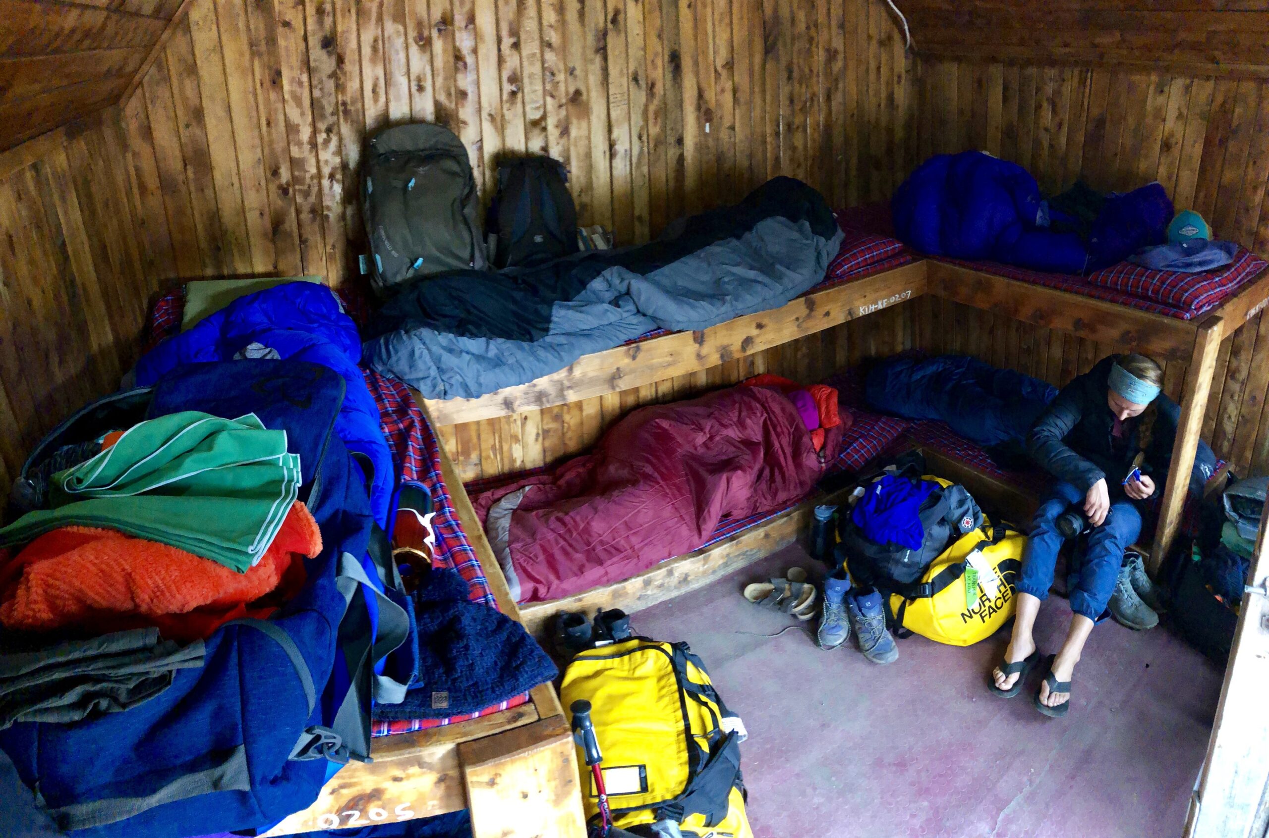 Sleeping bags and backpacks on bunk beds in a mountain hut