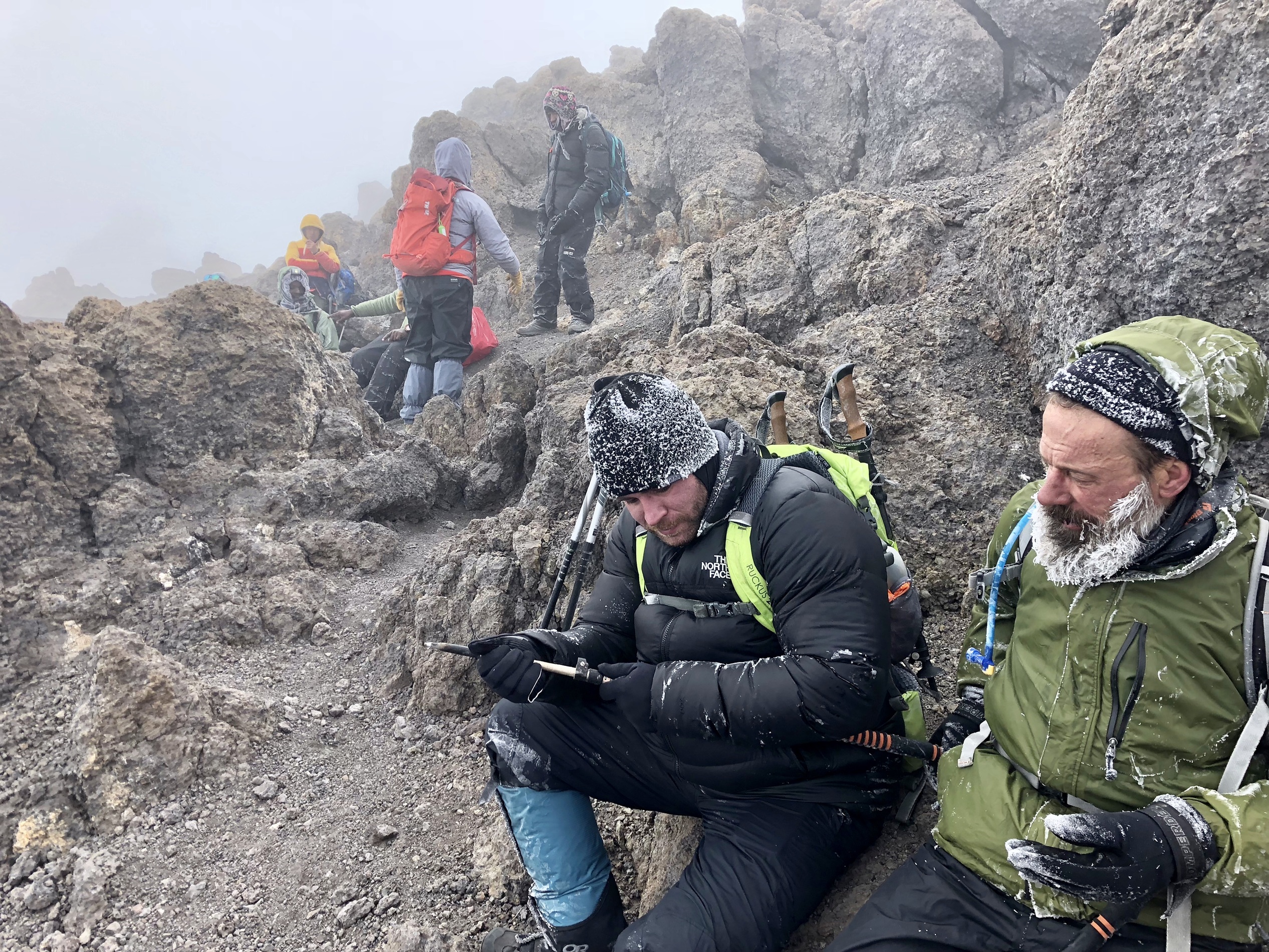 Tired and cold hikers after summiting Kilimanjaro