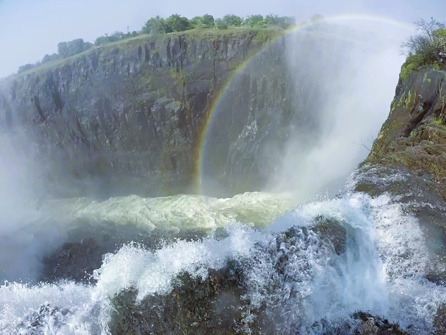 Rainbows and mist mixing at the edge of the Devil's Pool