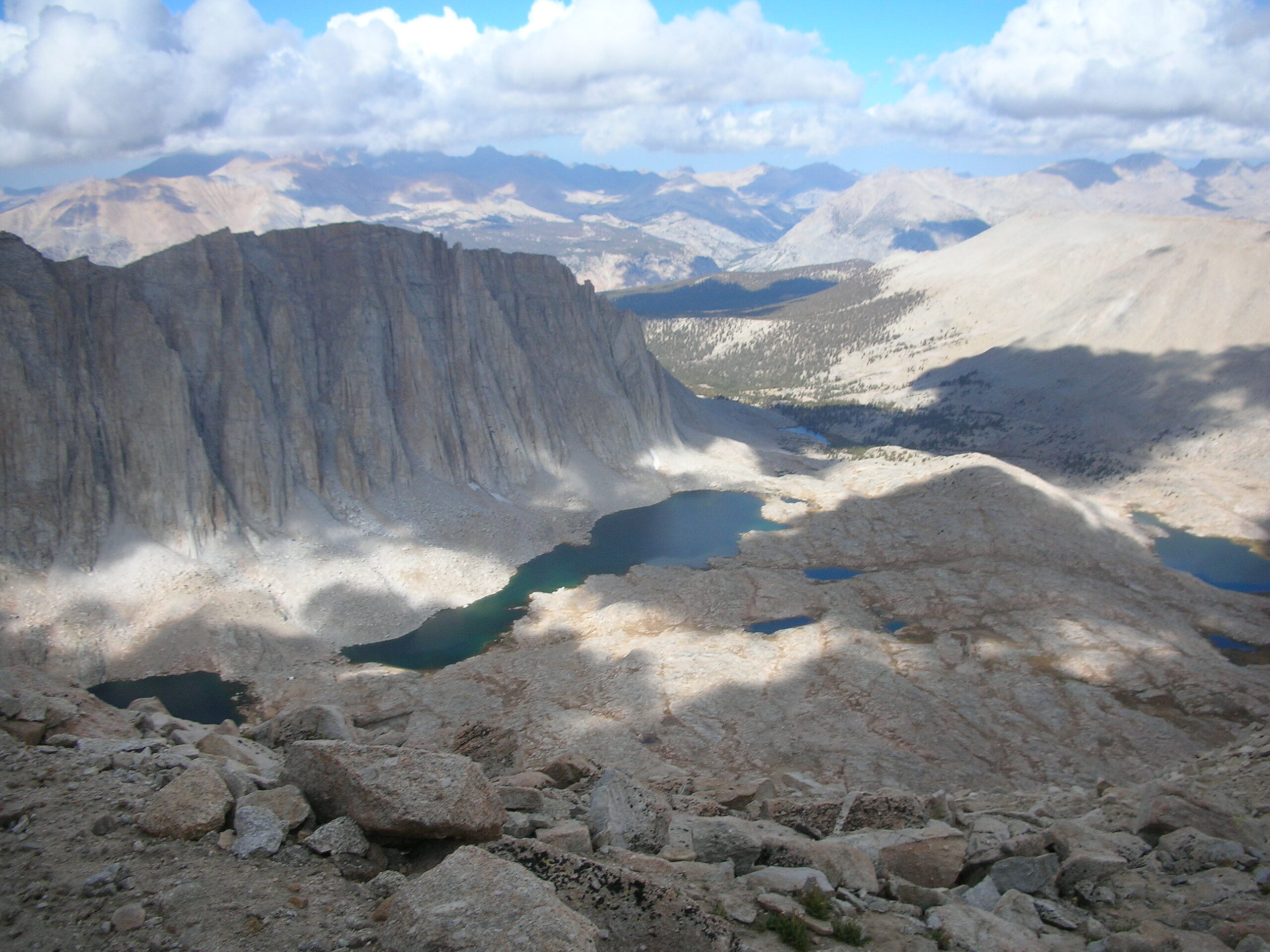 Looking down on the other side of the ridge, you see stark glacial lakes