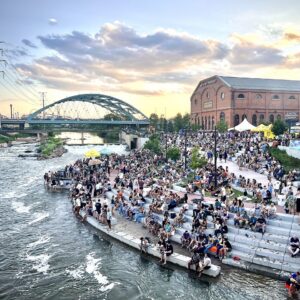 People sitting on steps by the river at Confluence Park in Denver