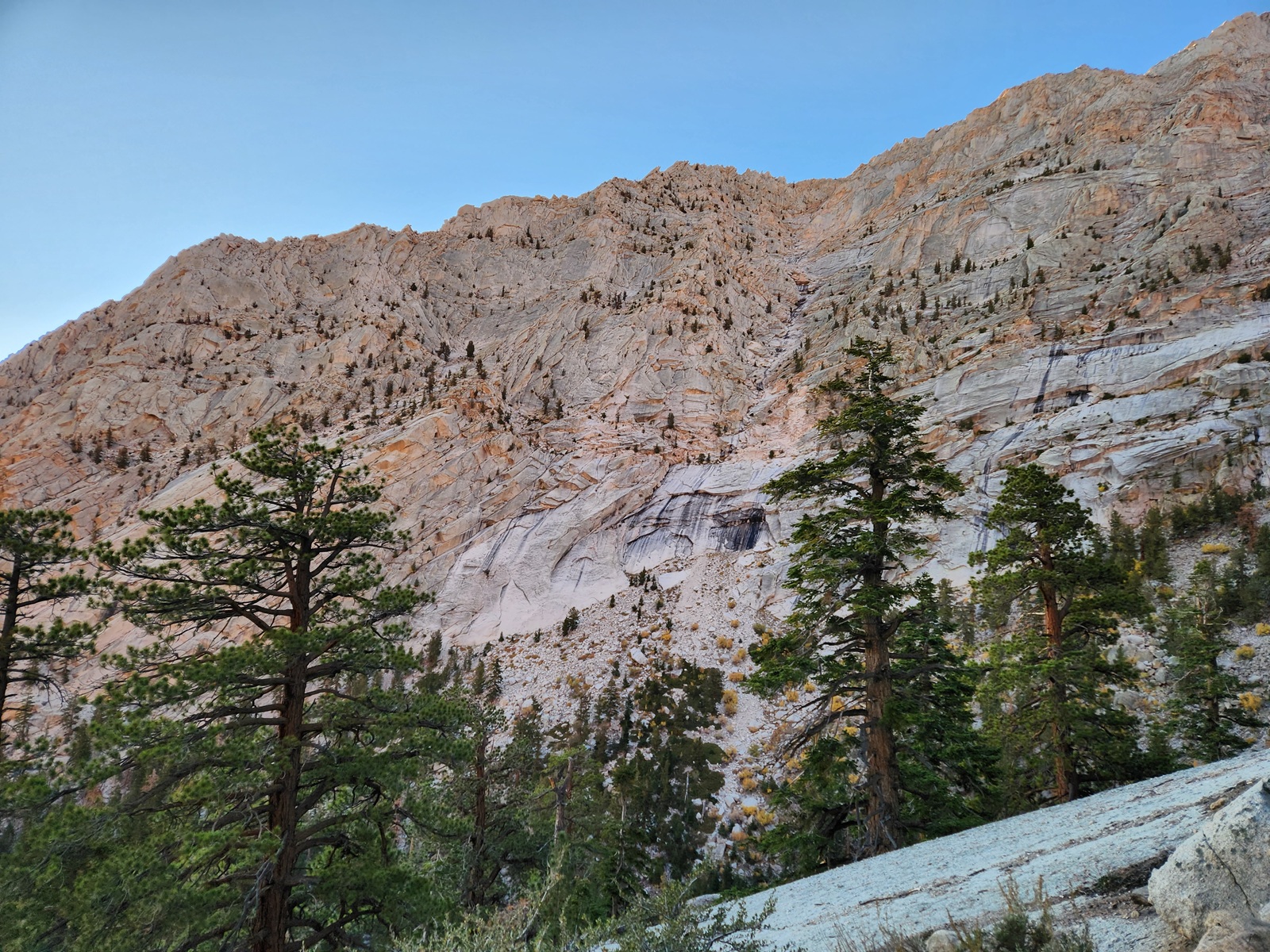 The tall granite walls tower over the trail