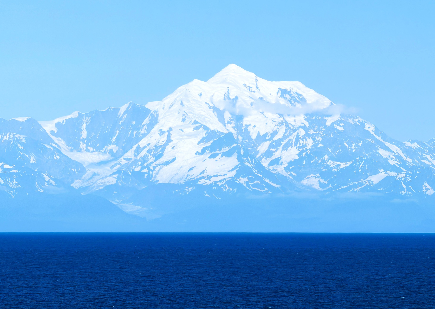 Mount Fairweather has a pyramid summit topped with snow right at the edge of the sea